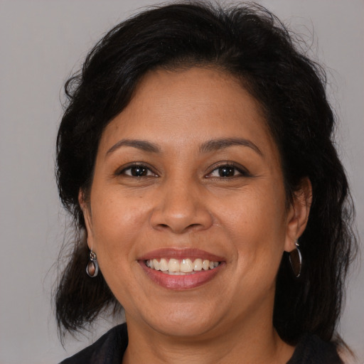 Joyful latino adult female with medium  brown hair and brown eyes