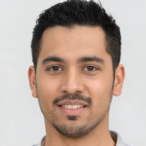 Joyful latino young-adult male with short  black hair and brown eyes