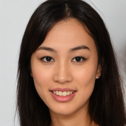 Joyful asian young-adult female with long  brown hair and brown eyes