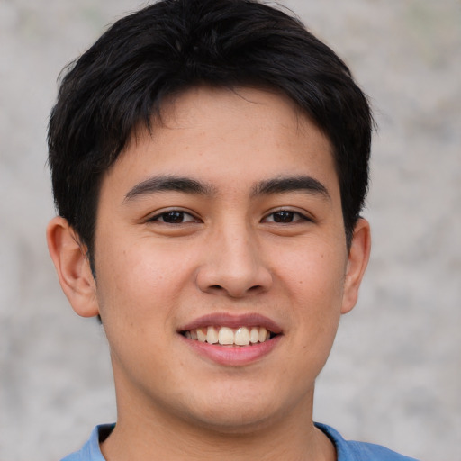 Joyful asian young-adult male with short  brown hair and brown eyes