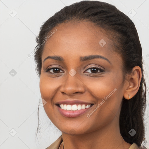 Joyful black young-adult female with long  brown hair and brown eyes