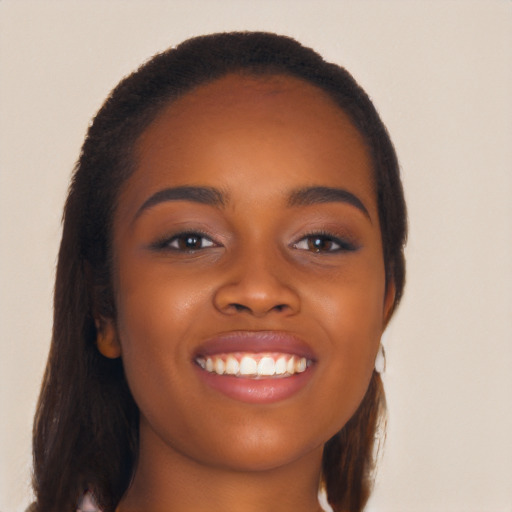 Joyful black young-adult female with long  brown hair and brown eyes