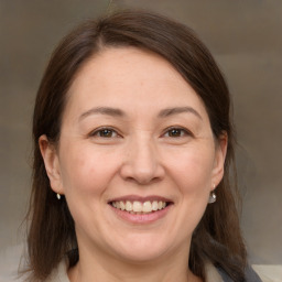 Joyful white adult female with medium  brown hair and brown eyes