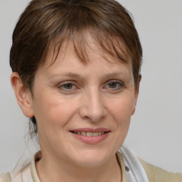 Joyful white adult female with short  brown hair and grey eyes