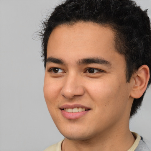 Joyful latino young-adult male with short  brown hair and brown eyes