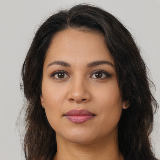 Joyful latino young-adult female with long  brown hair and brown eyes
