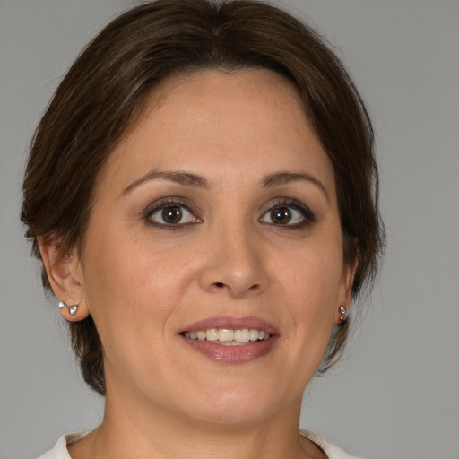 Joyful white adult female with medium  brown hair and brown eyes