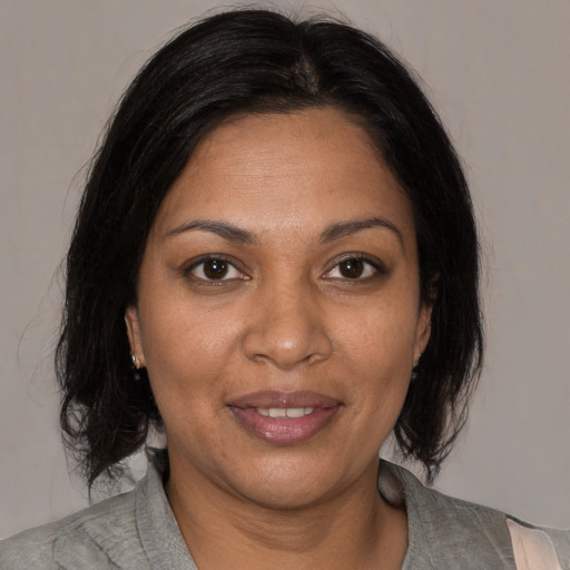 Joyful black adult female with medium  brown hair and brown eyes