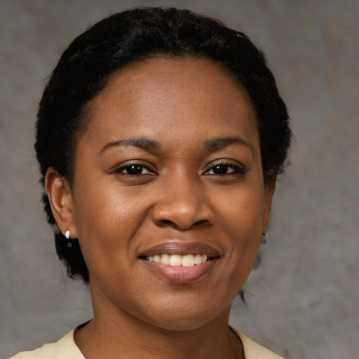 Joyful black young-adult female with short  black hair and brown eyes