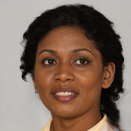 Joyful black adult female with medium  brown hair and brown eyes