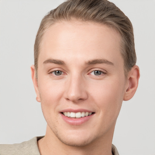 Joyful white young-adult male with short  brown hair and grey eyes