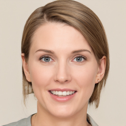 Joyful white young-adult female with medium  brown hair and green eyes