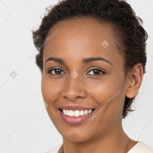 Joyful black young-adult female with short  brown hair and brown eyes