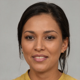 Joyful latino young-adult female with medium  brown hair and brown eyes