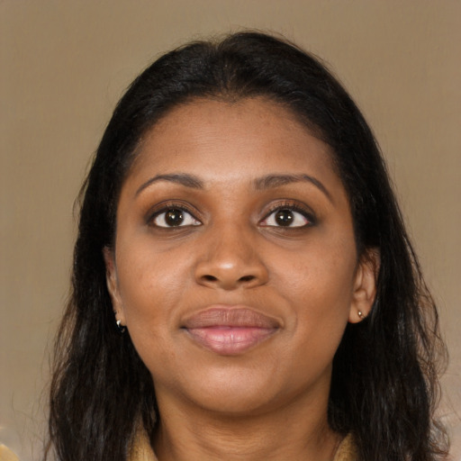 Joyful black young-adult female with long  brown hair and brown eyes
