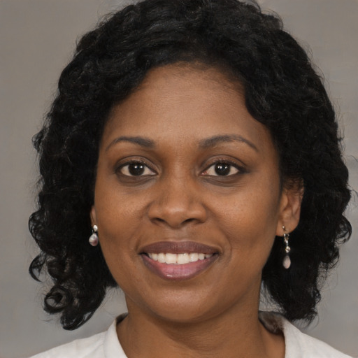 Joyful black adult female with long  black hair and brown eyes