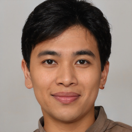 Joyful latino young-adult male with short  black hair and brown eyes