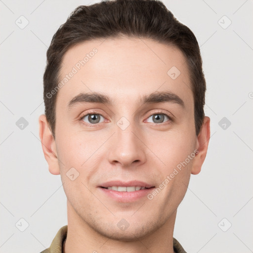 Joyful white young-adult male with short  brown hair and grey eyes