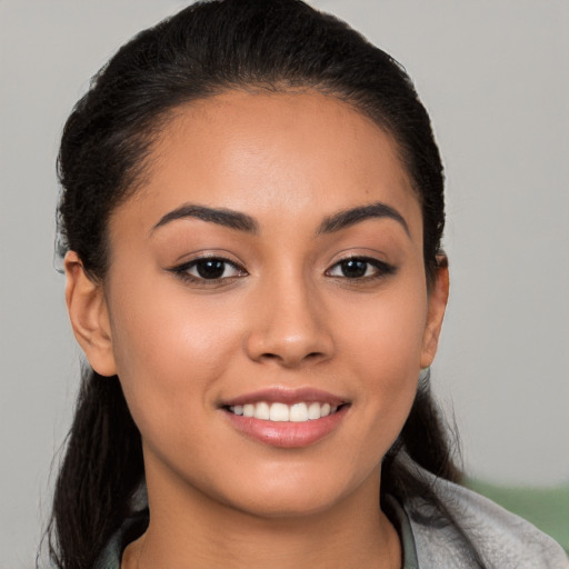 Joyful latino young-adult female with long  black hair and brown eyes