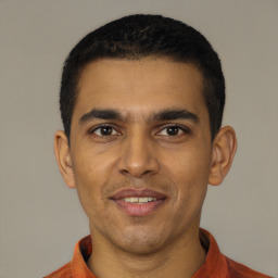 Joyful latino young-adult male with short  black hair and brown eyes