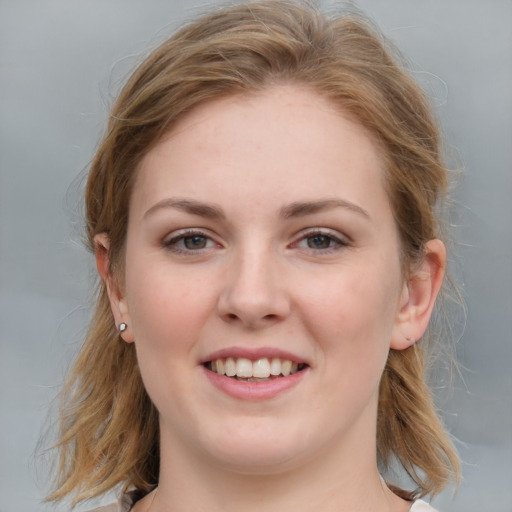 Joyful white young-adult female with medium  brown hair and blue eyes