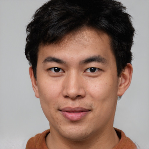 Joyful asian young-adult male with short  brown hair and brown eyes