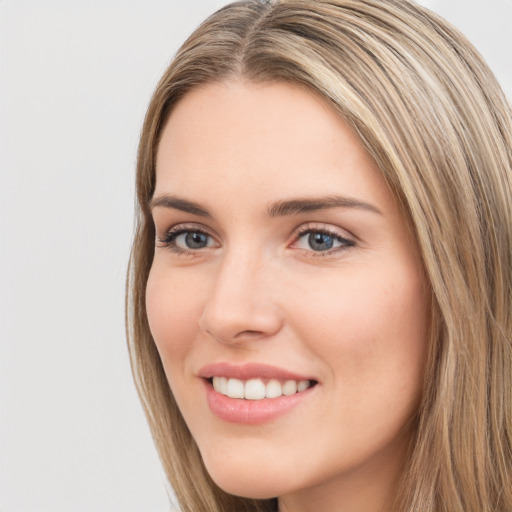 Joyful white young-adult female with long  brown hair and green eyes