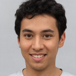 Joyful latino young-adult male with short  brown hair and brown eyes