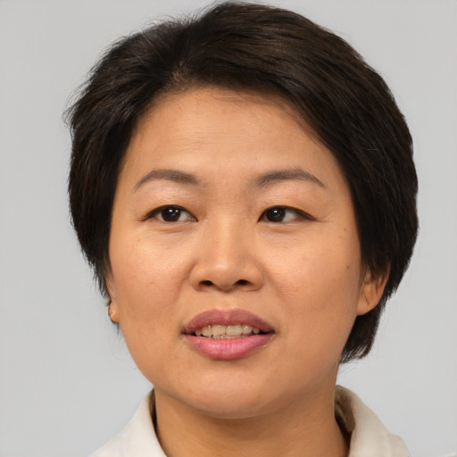 Joyful asian adult female with medium  brown hair and brown eyes