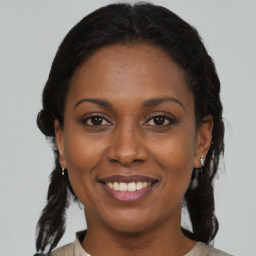 Joyful black adult female with medium  brown hair and brown eyes