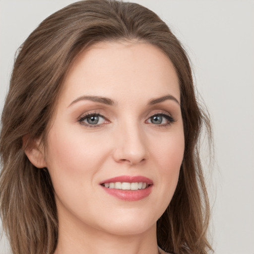 Joyful white young-adult female with long  brown hair and green eyes