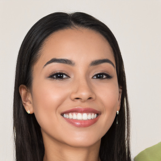 Joyful latino young-adult female with long  brown hair and brown eyes