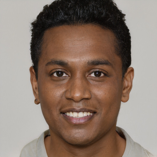 Joyful black young-adult male with short  black hair and brown eyes
