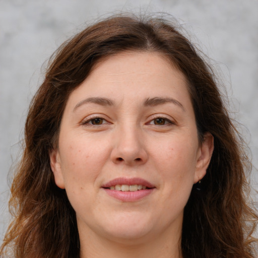 Joyful white adult female with long  brown hair and brown eyes