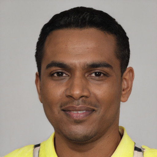 Joyful black young-adult male with short  black hair and brown eyes