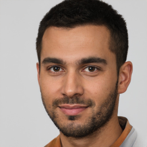 Joyful latino young-adult male with short  brown hair and brown eyes