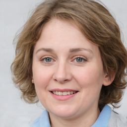 Joyful white adult female with medium  brown hair and blue eyes