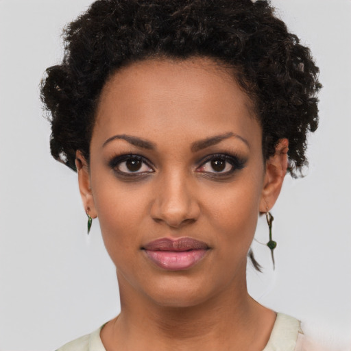 Joyful black young-adult female with short  brown hair and brown eyes