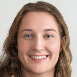 Joyful white young-adult female with long  brown hair and green eyes