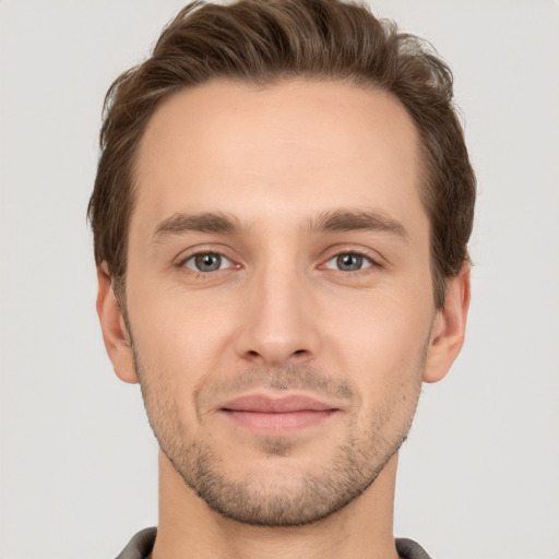 Joyful white young-adult male with short  brown hair and grey eyes