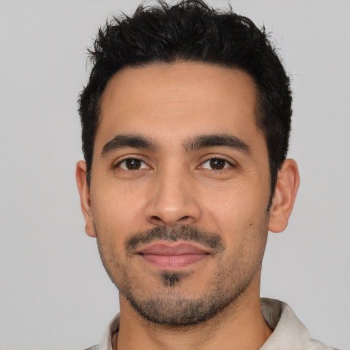 Joyful latino young-adult male with short  black hair and brown eyes