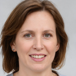 Joyful white adult female with medium  brown hair and grey eyes