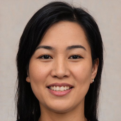 Joyful asian young-adult female with long  brown hair and brown eyes