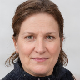 Joyful white adult female with medium  brown hair and blue eyes