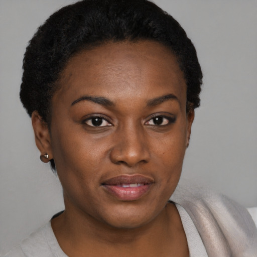 Joyful black young-adult female with short  black hair and brown eyes