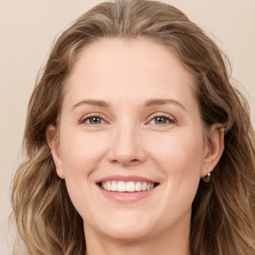 Joyful white young-adult female with long  brown hair and blue eyes