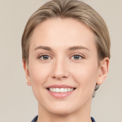 Joyful white young-adult female with short  brown hair and grey eyes