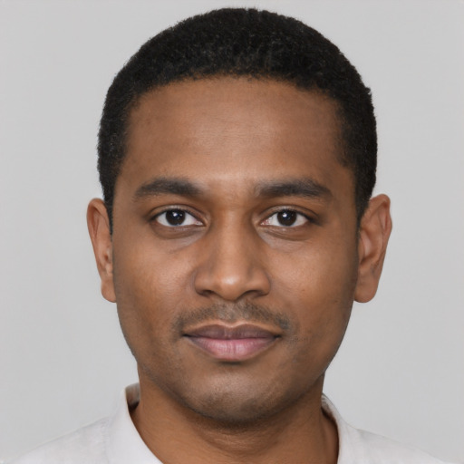 Joyful black young-adult male with short  black hair and brown eyes