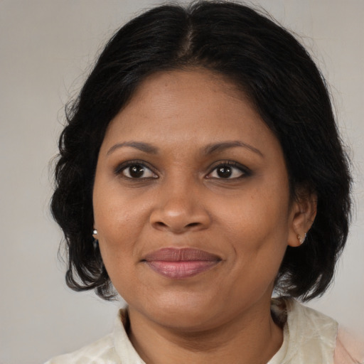 Joyful black adult female with medium  brown hair and brown eyes