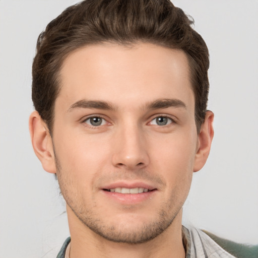 Joyful white young-adult male with short  brown hair and grey eyes